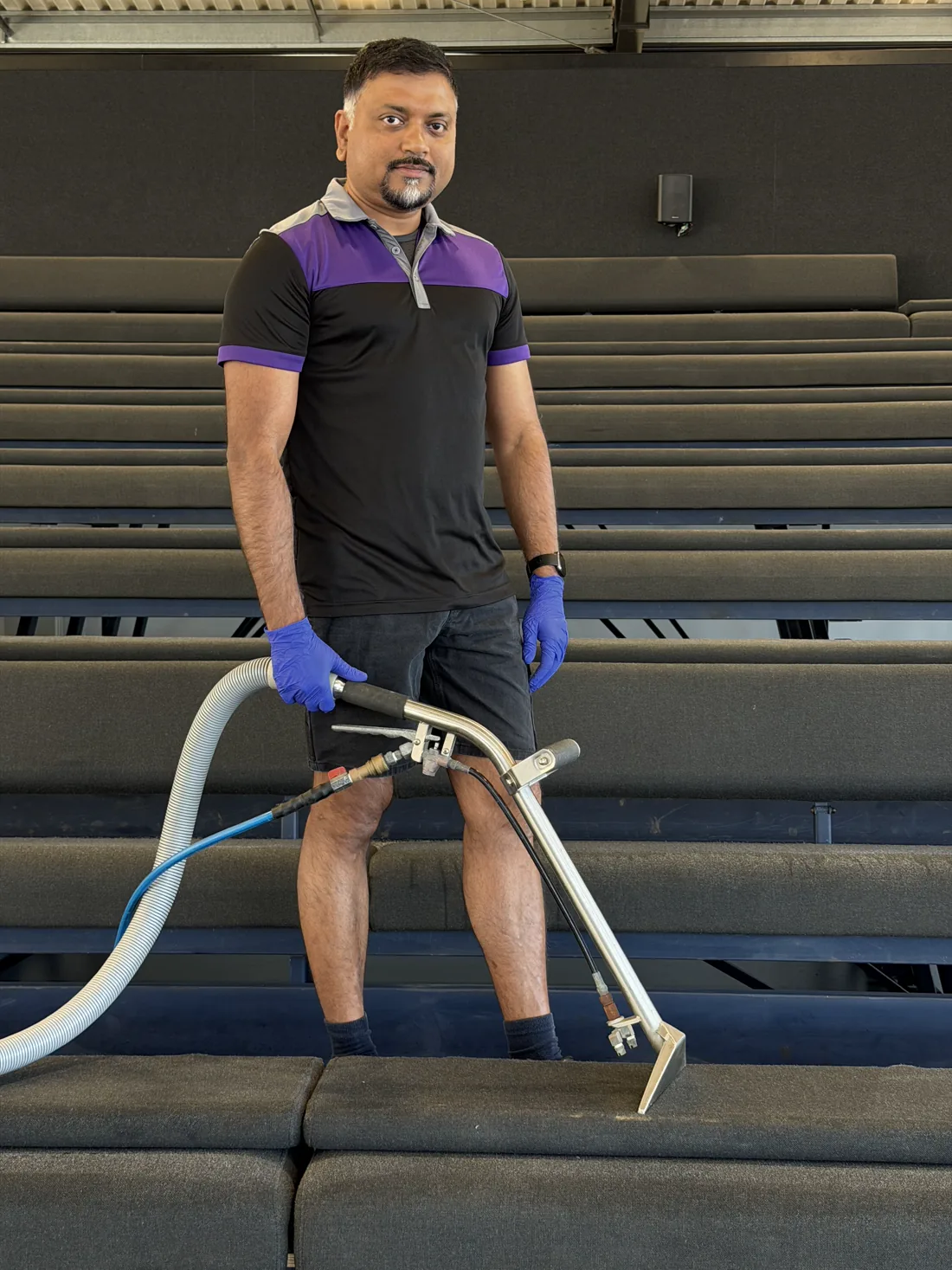 Bency John, ApexClean's owner-operator, cleaning with a van-mounted steam extraction wand in Auckland